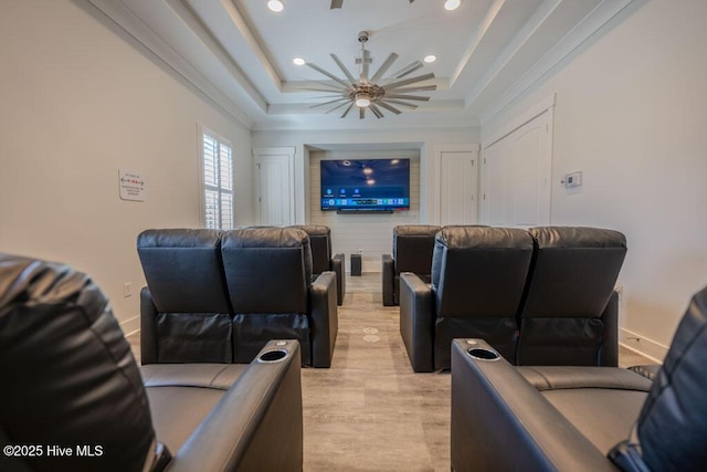 home theater room featuring light wood-style flooring, baseboards, a raised ceiling, and recessed lighting