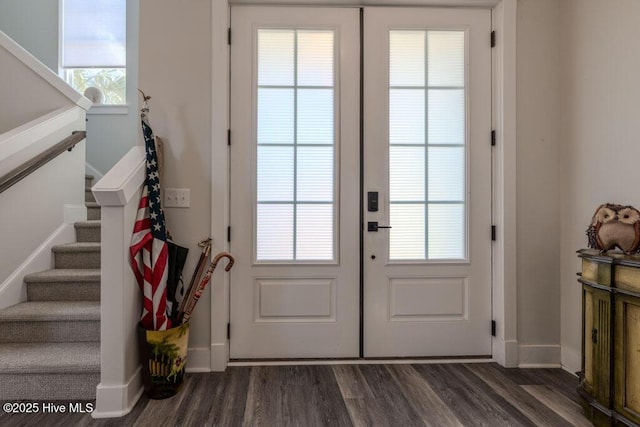 doorway featuring dark wood-style flooring, baseboards, and stairs