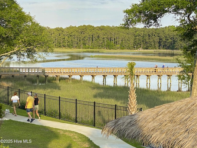 view of water feature featuring a forest view and fence