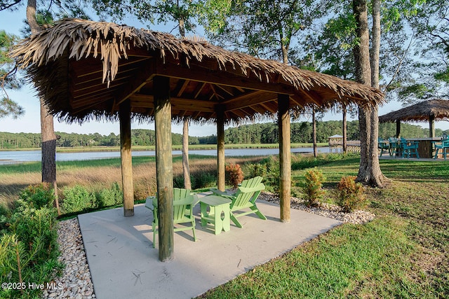 view of property's community with a gazebo, a lawn, and a water view