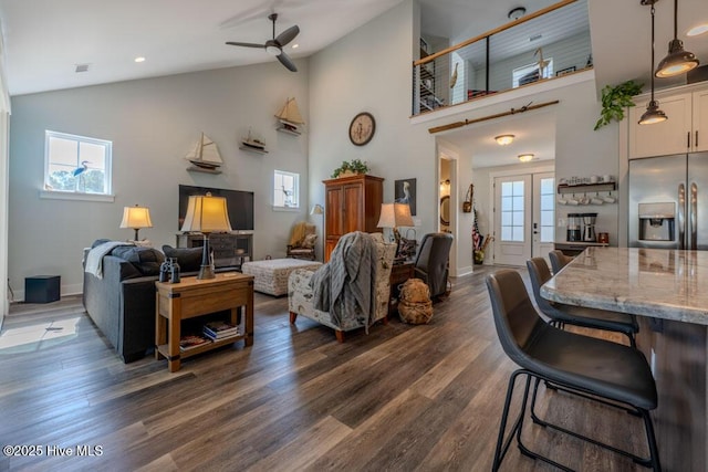 living area featuring dark wood-style floors, plenty of natural light, visible vents, and ceiling fan