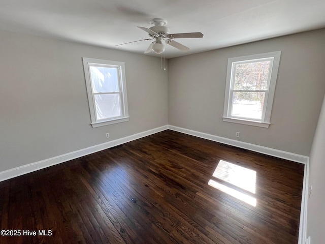 empty room with dark wood-style flooring, ceiling fan, and baseboards