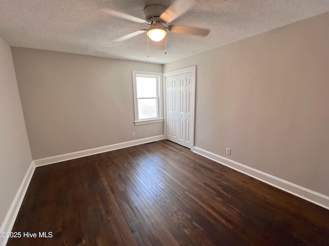 unfurnished bedroom with a closet, dark wood-style flooring, a textured ceiling, and baseboards