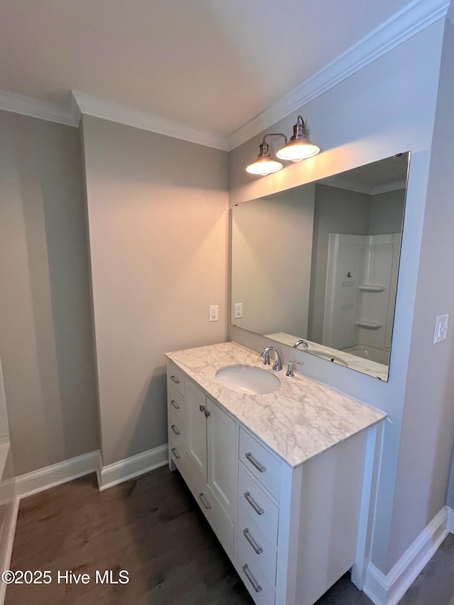 full bath featuring ornamental molding, wood finished floors, vanity, and baseboards