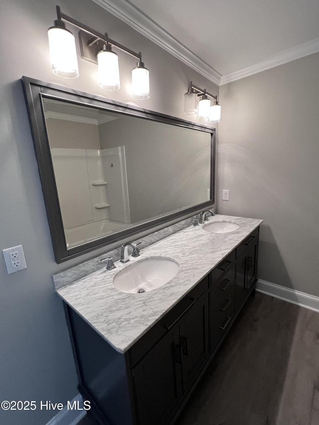 full bathroom with baseboards, wood finished floors, a sink, and crown molding