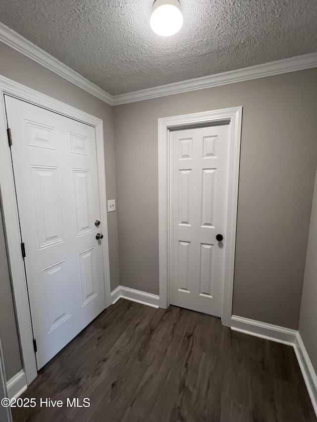 entryway featuring dark wood-style floors, crown molding, a textured ceiling, and baseboards