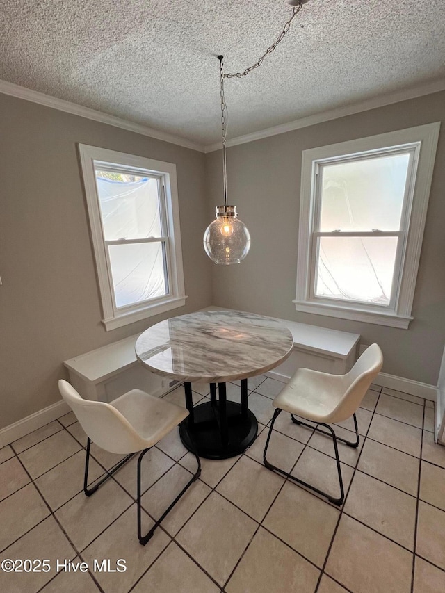 dining area featuring a textured ceiling, ornamental molding, and light tile patterned flooring