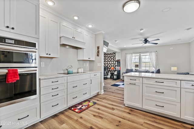 kitchen with black electric stovetop, recessed lighting, double oven, white cabinets, and light wood-type flooring