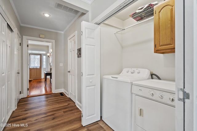 clothes washing area featuring separate washer and dryer, dark wood-style flooring, visible vents, cabinet space, and crown molding