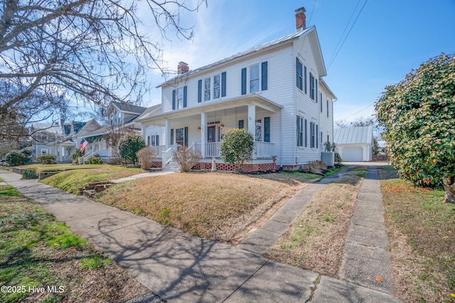 view of front of home with a porch, a chimney, an outdoor structure, and a front lawn