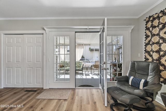 entryway featuring ornamental molding and wood finished floors