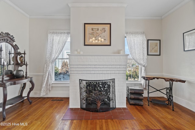 living area featuring ornamental molding, a fireplace, baseboards, and hardwood / wood-style flooring