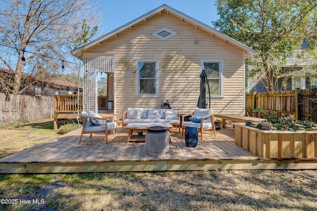 back of house featuring fence, an outdoor living space, and a wooden deck