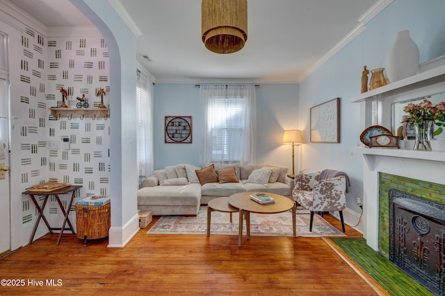 living room with visible vents, a fireplace, ornamental molding, and wood finished floors