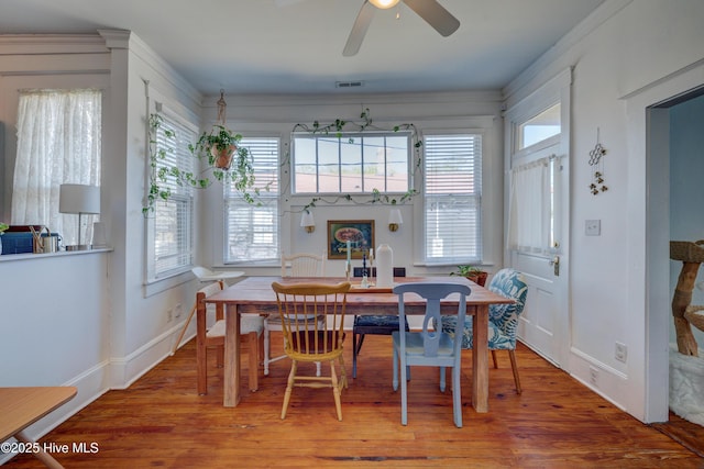 dining area featuring a ceiling fan, baseboards, visible vents, and wood finished floors