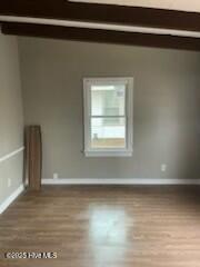 empty room with baseboards and wood finished floors