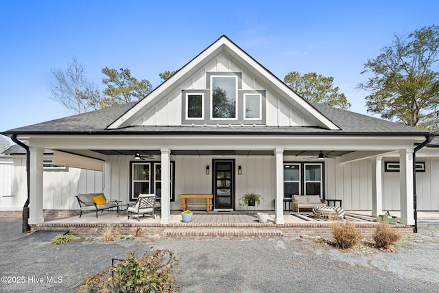 view of front of home with board and batten siding, a shingled roof, a patio, and a ceiling fan