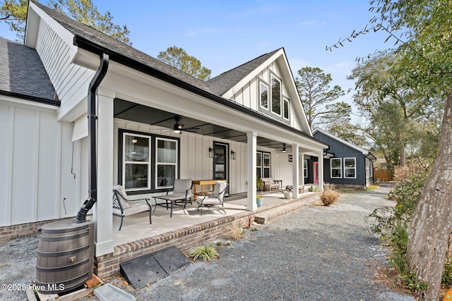 back of house featuring ceiling fan, a patio, board and batten siding, and roof with shingles