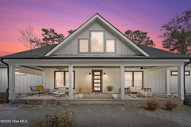 rear view of house with covered porch, ceiling fan, a shingled roof, and board and batten siding