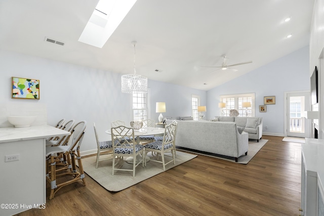 212 Florida Ave, Carolina Beach, NC 28428 - dining area with dark wood finished floors, a chandelier, a skylight, ceiling fan, and baseboards