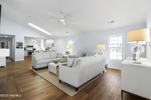 living room with baseboards, visible vents, dark wood-style floors, high vaulted ceiling, and ceiling fan with notable chandelier