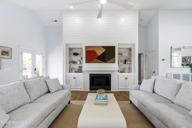 212 Florida Ave, Carolina Beach, NC 28428 - living room featuring dark wood-style flooring, a ceiling fan, a fireplace, high vaulted ceiling, and built in shelves