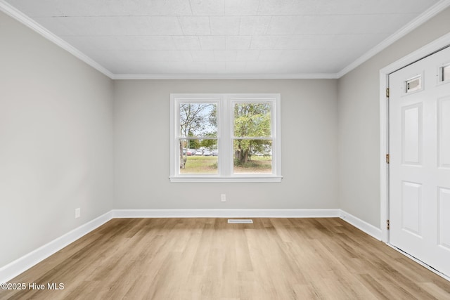 empty room with light wood-type flooring, visible vents, baseboards, and crown molding