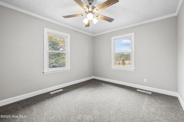 carpeted spare room featuring a wealth of natural light, visible vents, and baseboards