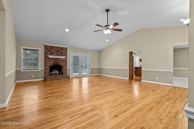 unfurnished living room with a wealth of natural light, french doors, and light wood-style flooring