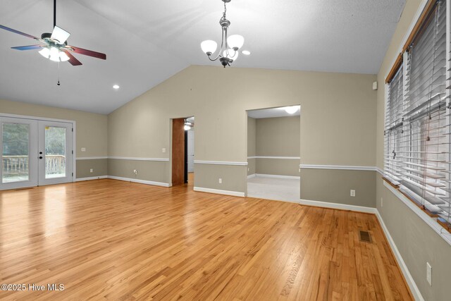 unfurnished living room featuring visible vents, baseboards, lofted ceiling, light wood-style flooring, and french doors