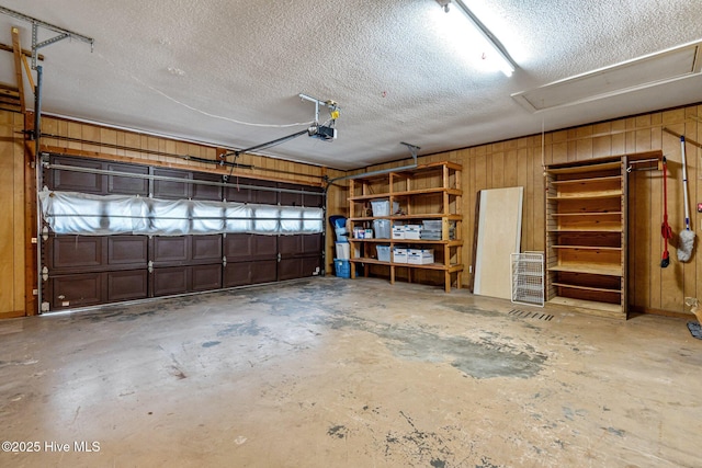 garage featuring wood walls and a garage door opener