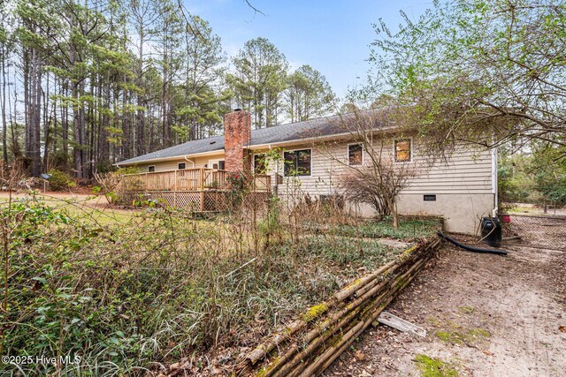 back of property with crawl space, a chimney, and a wooden deck