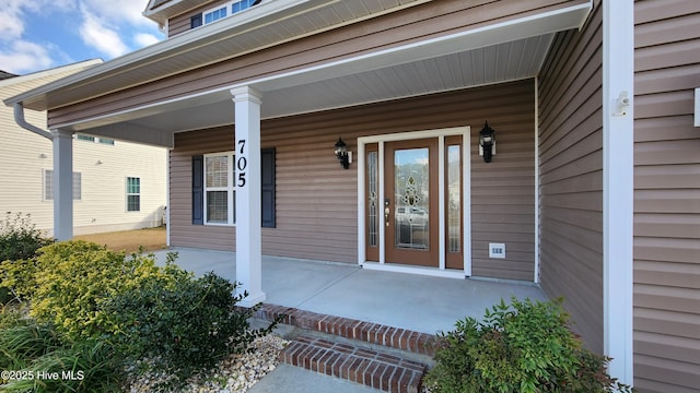 view of exterior entry with a porch