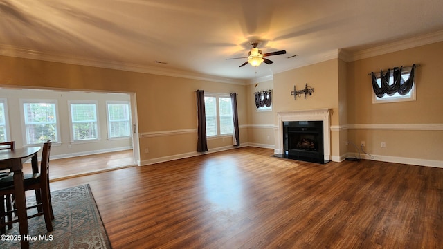 unfurnished living room with dark wood-type flooring, a fireplace with raised hearth, ornamental molding, and baseboards