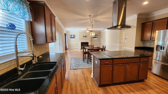 kitchen with island range hood, a fireplace, a center island, stainless steel fridge with ice dispenser, and crown molding