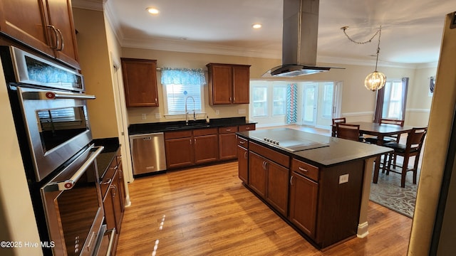 kitchen with appliances with stainless steel finishes, dark countertops, a center island, and island range hood