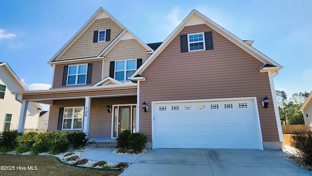 view of front of home with an attached garage, a porch, and concrete driveway