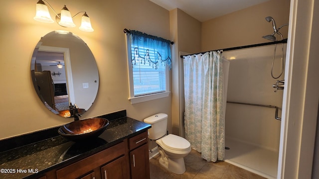 bathroom with toilet, curtained shower, tile patterned flooring, and vanity