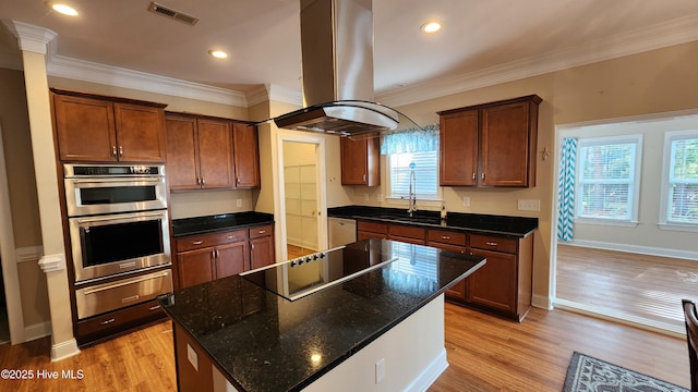 kitchen with island exhaust hood, a warming drawer, stainless steel appliances, visible vents, and dark stone counters