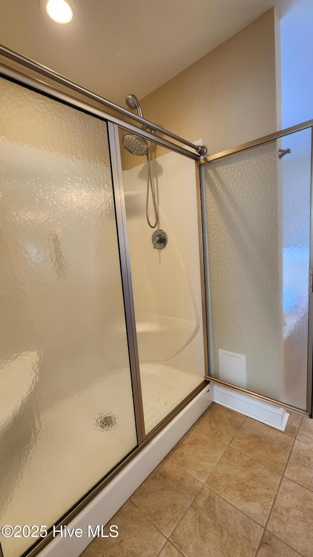 full bath with tile patterned flooring and a shower stall