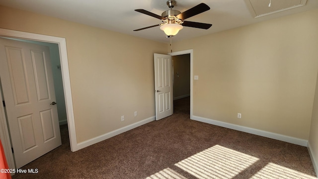 unfurnished bedroom with baseboards, dark carpet, and ceiling fan