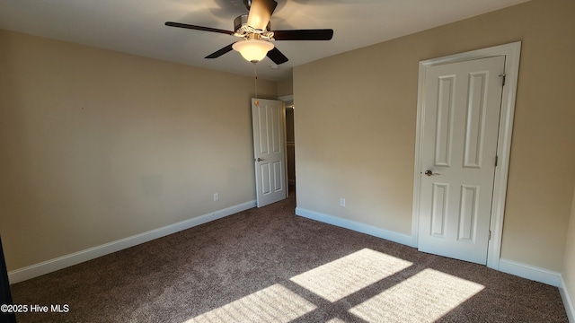 unfurnished bedroom featuring dark colored carpet, ceiling fan, and baseboards