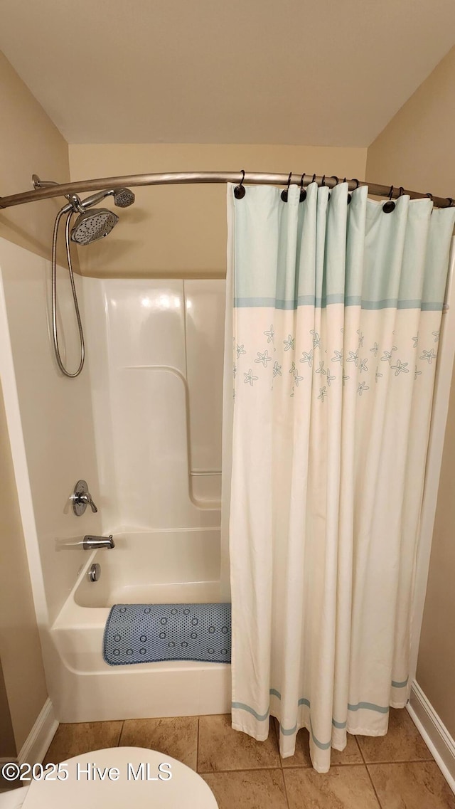 full bath with toilet, tile patterned flooring, and baseboards