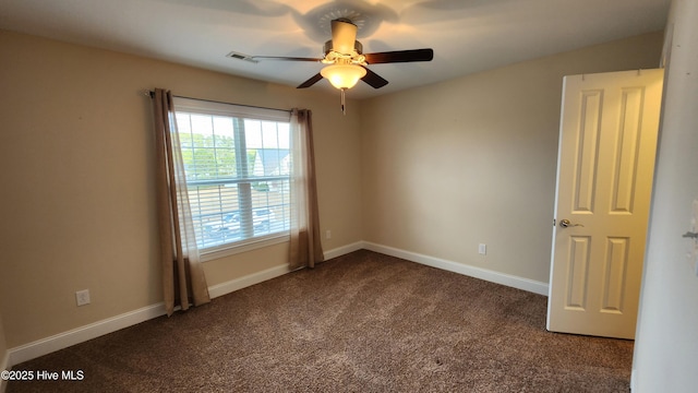 unfurnished room featuring ceiling fan, dark colored carpet, visible vents, and baseboards