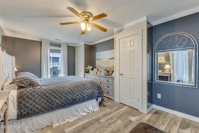 bedroom with light wood-style floors, ceiling fan, a textured ceiling, and baseboards