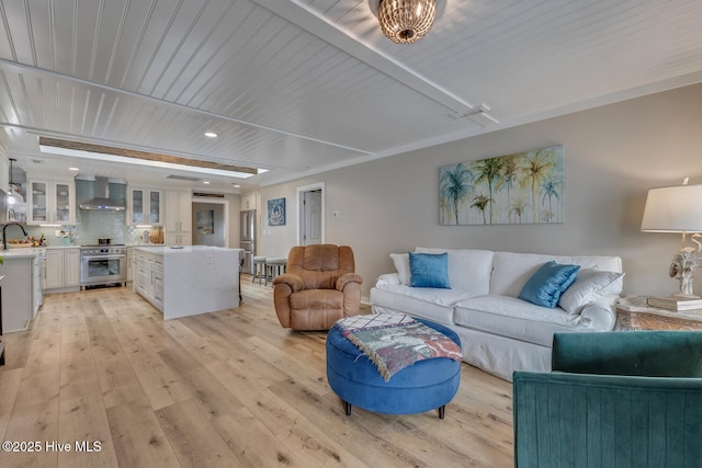 living room with beam ceiling and light wood-style floors