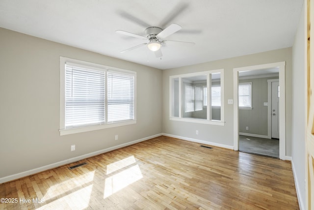 empty room with visible vents, baseboards, and wood finished floors