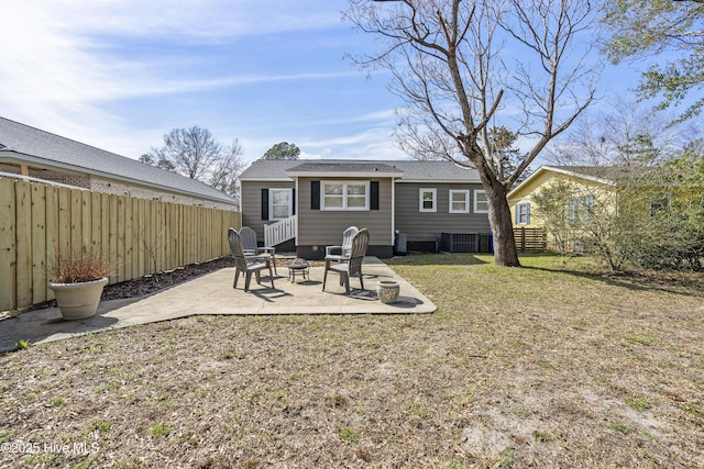 rear view of house with an outdoor fire pit, central AC unit, a patio, fence, and a yard