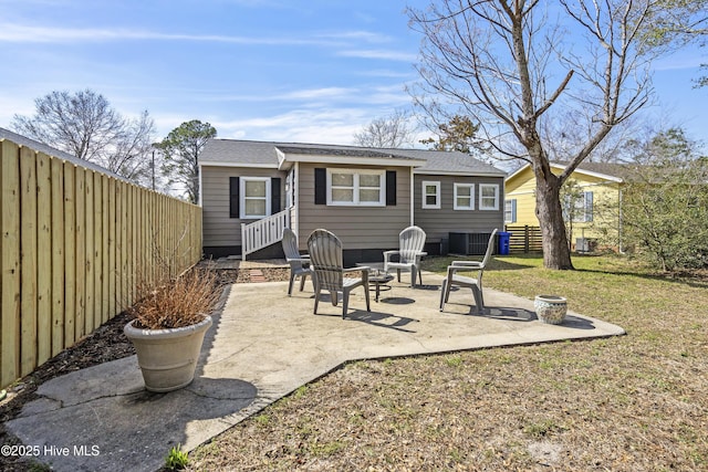 back of house with a fire pit, fence, cooling unit, a yard, and a patio area