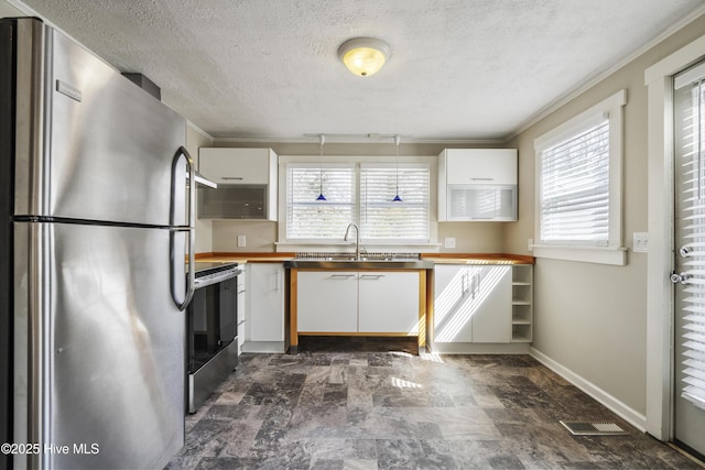 kitchen with visible vents, appliances with stainless steel finishes, white cabinets, a sink, and a textured ceiling